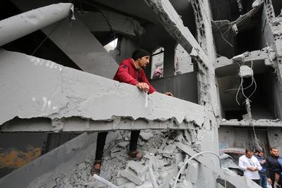 Palestinians inspect the rubble of a building following an Israeli strike on a residential area in Gaza City's Shujaiyya-stock-foto