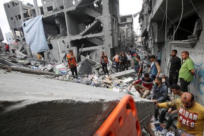 Palestinians inspect the rubble of a building following an Israeli strike on a residential area in Gaza City's Shujaiyya-stock-foto