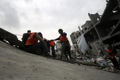 Palestinians inspect the rubble of a building following an Israeli strike on a residential area in Gaza City's Shujaiyya-stock-foto