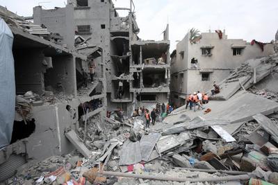 Palestinians inspect the rubble of a building following an Israeli strike on a residential area in Gaza City's Shujaiyya-stock-foto