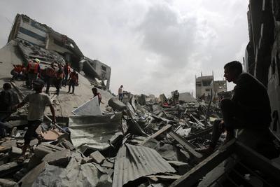 Palestinians inspect the rubble of a building following an Israeli strike on a residential area in Gaza City's Shujaiyya-stock-foto