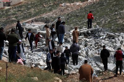 Palestinians from Al-Hirsh family salvage belongings from the ruins of their houses after they were demolished-stock-foto