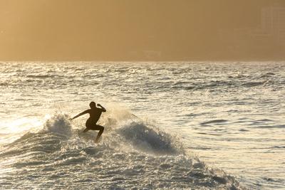 Surfer auf den Wellen bei Sonnenuntergang am Strand von Ipanema in Rio de Janeiro in Brasilien-stock-photo