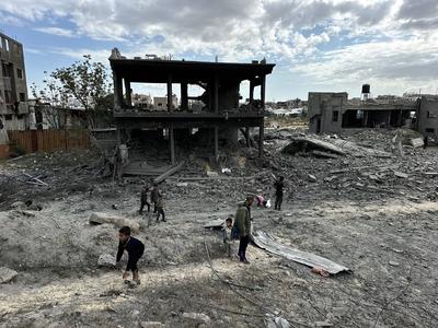 Palestinians inspect the site of an Israeli strike on tents and buildings site housing displaced people, in Khan Younis-stock-photo