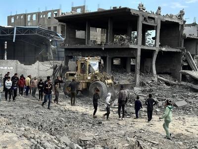 Palestinians inspect the site of an Israeli strike on tents and buildings site housing displaced people, in Khan Younis-stock-photo