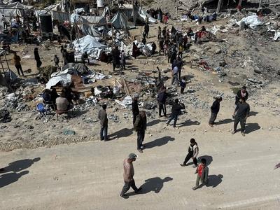 Palestinians inspect the site of an Israeli strike on tents and buildings site housing displaced people, in Khan Younis-stock-photo