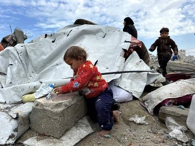 Palestinians inspect the site of an Israeli strike on tents and buildings site housing displaced people, in Khan Younis-stock-photo