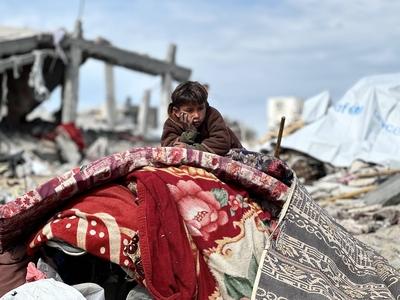 Palestinians inspect the site of an Israeli strike on tents and buildings site housing displaced people, in Khan Younis-stock-photo