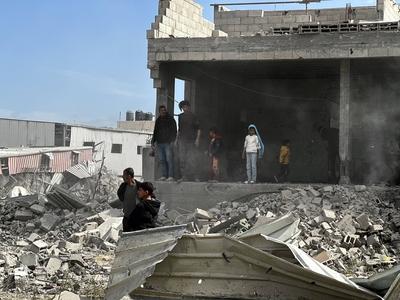 Palestinians inspect the site of an Israeli strike on tents and buildings site housing displaced people, in Khan Younis-stock-photo