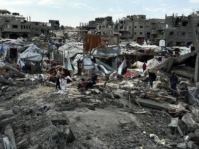 Palestinians inspect the site of an Israeli strike on tents and buildings site housing displaced people, in Khan Younis-stock-photo