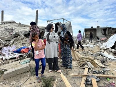 Palestinians inspect the site of an Israeli strike on tents and buildings site housing displaced people, in Khan Younis-stock-photo