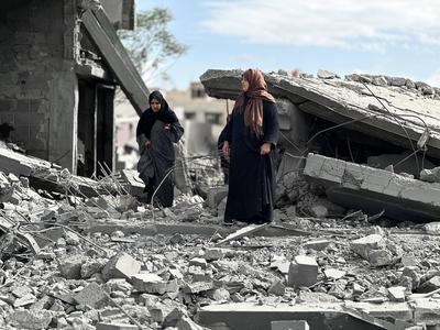 Palestinians inspect the site of an Israeli strike on tents and buildings site housing displaced people, in Khan Younis-stock-photo