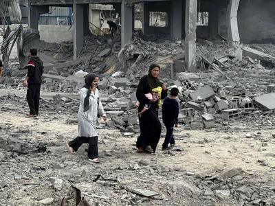 Palestinians inspect the site of an Israeli strike on tents and buildings site housing displaced people, in Khan Younis-stock-photo
