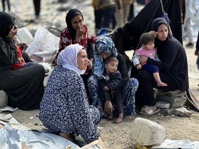 Palestinians inspect the site of an Israeli strike on tents and buildings site housing displaced people, in Khan Younis-stock-photo