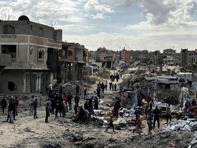 Palestinians inspect the site of an Israeli strike on tents and buildings site housing displaced people, in Khan Younis-stock-photo