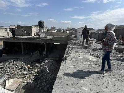 Palestinians inspect the site of an Israeli strike on tents and buildings site housing displaced people, in Khan Younis-stock-photo