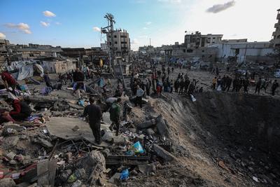Palestinians gather around a large crater following an Israeli strike on a metalsmith workshop at the Zaytoun neighbouhood in Gaza City-stock-photo