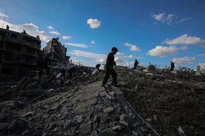 Palestinians gather around a large crater following an Israeli strike on a metalsmith workshop at the Zaytoun neighbouhood in Gaza City-stock-photo