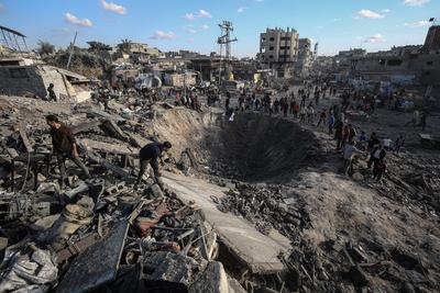 Palestinians gather around a large crater following an Israeli strike on a metalsmith workshop at the Zaytoun neighbouhood in Gaza City-stock-photo