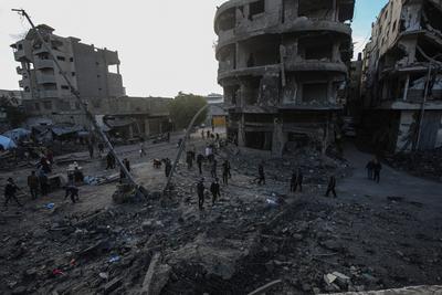 Palestinians gather around a large crater following an Israeli strike on a metalsmith workshop at the Zaytoun neighbouhood in Gaza City-stock-photo