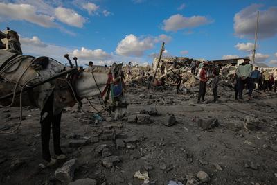Palestinians gather around a large crater following an Israeli strike on a metalsmith workshop at the Zaytoun neighbouhood in Gaza City-stock-photo