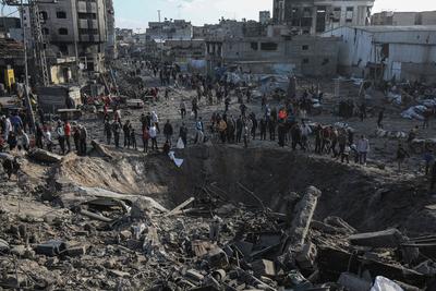 Palestinians gather around a large crater following an Israeli strike on a metalsmith workshop at the Zaytoun neighbouhood in Gaza City-stock-photo