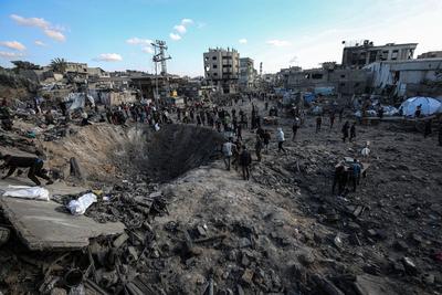 Palestinians gather around a large crater following an Israeli strike on a metalsmith workshop at the Zaytoun neighbouhood in Gaza City-stock-photo