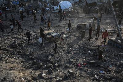 Palestinians gather around a large crater following an Israeli strike on a metalsmith workshop at the Zaytoun neighbouhood in Gaza City-stock-photo