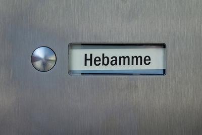 Klingelschild mit dem Schriftzug Hebamme-stock-foto