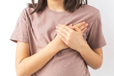 Kind h?lt die Brust mit beiden H?nden, dr?ckt Herzbeschwerden oder Schmerzen Konzept auf wei?em Hintergrund-stock-photo