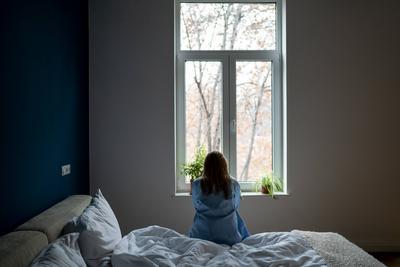 Alone woman sit on bed at home pondering solution trouble, suffer from breakup, divorce, feel unwell-stock-foto