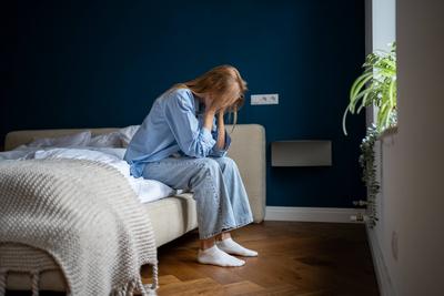 Depressive einsame Frau sitzt zu Hause auf dem Bett und denkt ?ber Probleme nach, Trennung, Scheidung, Unwohlsein-stock-foto