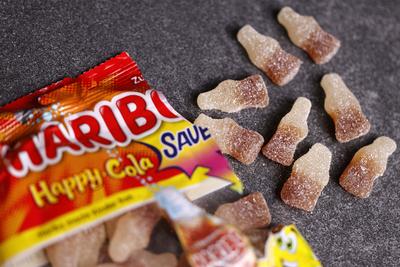 Saure Colafl?schchen von Haribo liegen auf einem Tisch. Haribo Happy Cola sauer ist ein Weingummi-Produkt einer Geschmac-stock-photo
