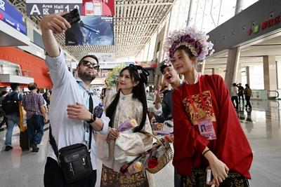 GUANGZHOU, CHINA - APRIL 15: A foreign purchaser poses for a selfie with staff members dressed in traditional Han costum-stock-foto