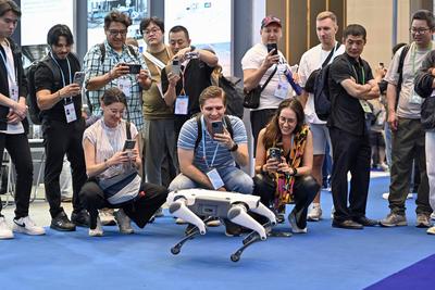 GUANGZHOU, CHINA - APRIL 15: Foreign buyers take photos of a quadruped robot dog during the 137th session of the China I-stock-foto