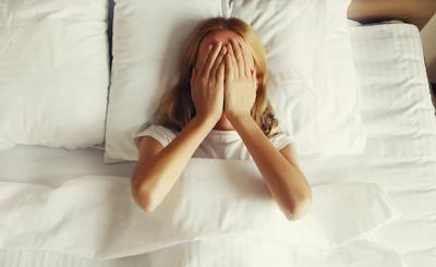 Aufgew?hlte, traurige, weinende Frau, die auf dem Bett liegt und seelisches Leid erf?hrt-stock-foto