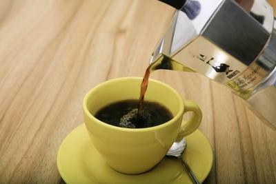 Tasse wird mit Kaffee aus der Bialetti Espressokanne Moka Express gef?llt Kochen speziell Zuberei-stock-foto