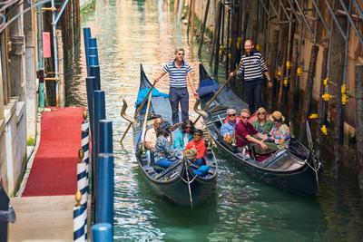 Venice, Italy - May 3, 2024: Gondolier takes tourists on a gondola ride through the picturesque city of Venice in Italy-stock-foto