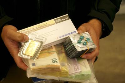 Viagra, Testosteron, Aufputschmittel Medikamente Verpackungen Gold und Geld zeigen Zollbeamte waehrend der Zoll Praesentation von sichergestellten Dopingmitteln, Drogen und Vermoegenswerten wie Bargeld und Gold in einer Halle auf dem Gelaende des Zollfahndungsamtes Hamburg17.04.2025 Der Hamburger Zoll hat einen illegalen Dopingmittel und Drogenvertrieb zerschlagen Die Beamten hatten einen Haendlerring von 3 Bruedern festgenommen die Sachen sichergestellt.Dabei wurden Verm?genswerte in H?he von 189.000 Euro in Bar sowie Gold im Wert von 50.000 Euro Hamburg Deutschland *** Viagra, testosterone, stimulant drugs packaging Gold and money are shown by customs officers during the customs presentation of seized doping agents, drugs and assets su-stock-foto