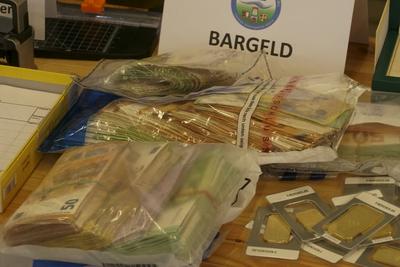 Gold Goldbarren Feingold und Geld Euroscheine Bargeld liegen auf einem Tisch waehrend der Zoll Praesentation von sichergestellten Dopingmitteln, Drogen und Vermoegenswerten wie Bargeld und Gold in einer Halle auf dem Gelaende des Zollfahndungsamtes Hamburg17.04.2025 Der Hamburger Zoll hat einen illegalen Dopingmittel und Drogenvertrieb zerschlagen Die Beamten hatten einen Haendlerring von 3 Bruedern festgenommen die Sachen sichergestellt.Dabei wurden Verm?genswerte in H?he von 189.000 Euro in Bar sowie Gold im Wert von 50.000 Euro Hamburg Deutschland *** Gold Gold bars Fine gold and money Euro bills Cash lie on a table during the customs presentation of seized doping agents, drugs and assets such as cash and gold in a hall on the premise-stock-foto