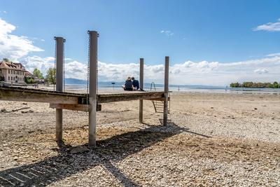 Durch Trockenheit freigelegte Uferzone am Bodensee, Badesteg ist 50 Meter vom Wasser entfernt, Wasserburg, 21. April 2025-stock-foto