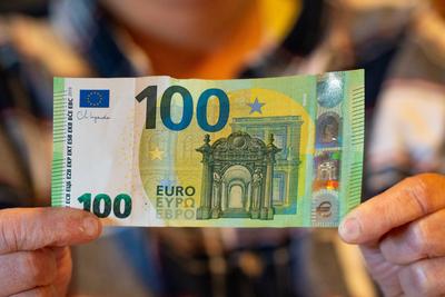 Bavaria, Germany - March 2, 2025: A 100 euro bill is presented by both hands. The image stands for financial independenc-stock-foto