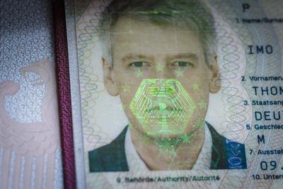 Symbolfoto: Auf dem Biometrischen Passfoto eines Reisepasses spiegelt sich ein Bundesadler als Hologramm. Berlin, 09.01-stock-foto