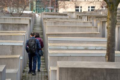 Berlin, Germany - March 23, 2025: Tourists walk through the stone steles of the Memorial to the Murdered Jews of Europe-stock-photo