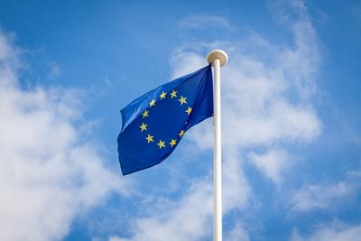 Europ?ische Flagge an einem Fahnenmast vor blauem Himmel The fluttering flag of European Union on a-stock-photo