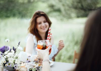 Cheerful woman with cocktail during banquet Happy young female with alcohol cocktail smiling and proposing toast while s-stock-foto