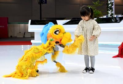 FUZHOU, CHINA - APRIL 28: A child interacts with a robot dog at the on-site experience area of 8th Digital China Summit-stock-foto