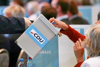 Berlin, Deutschland, 28.04.2025: Estrel: CDU-Bundesausschuss: Delegierte werfen eine Stimmkarte in eine Wahlurne *** Ber-stock-photo