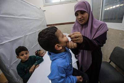 A member of staff administers medical drops to a Palestinian child at the UNRWA-run clinic-stock-foto
