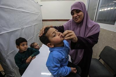 A member of staff administers medical drops to a Palestinian child at the UNRWA-run clinic-stock-foto